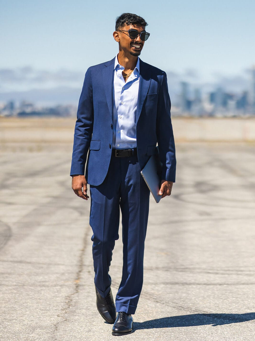 Man walking in parking lot with shades wearing Anatoly & Sons Blue Drago Skyfall Suit